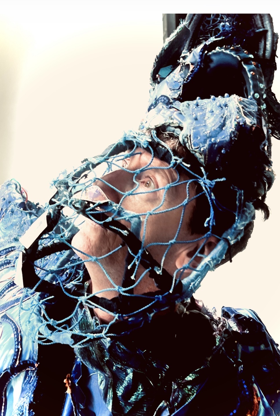 Blue netted costume headpiece in mixed-reality opera production